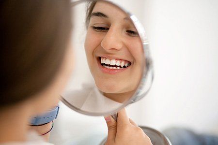 woman checking her teeth | fluoride treatment | Dentist Near Me Wellington