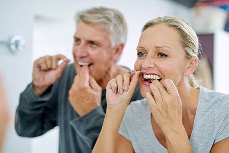 older couple flossing their teeth, preventative care |  Dentist In Wellington
