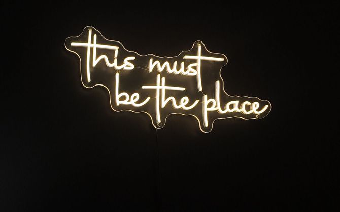 A neon sign that says this must be the place