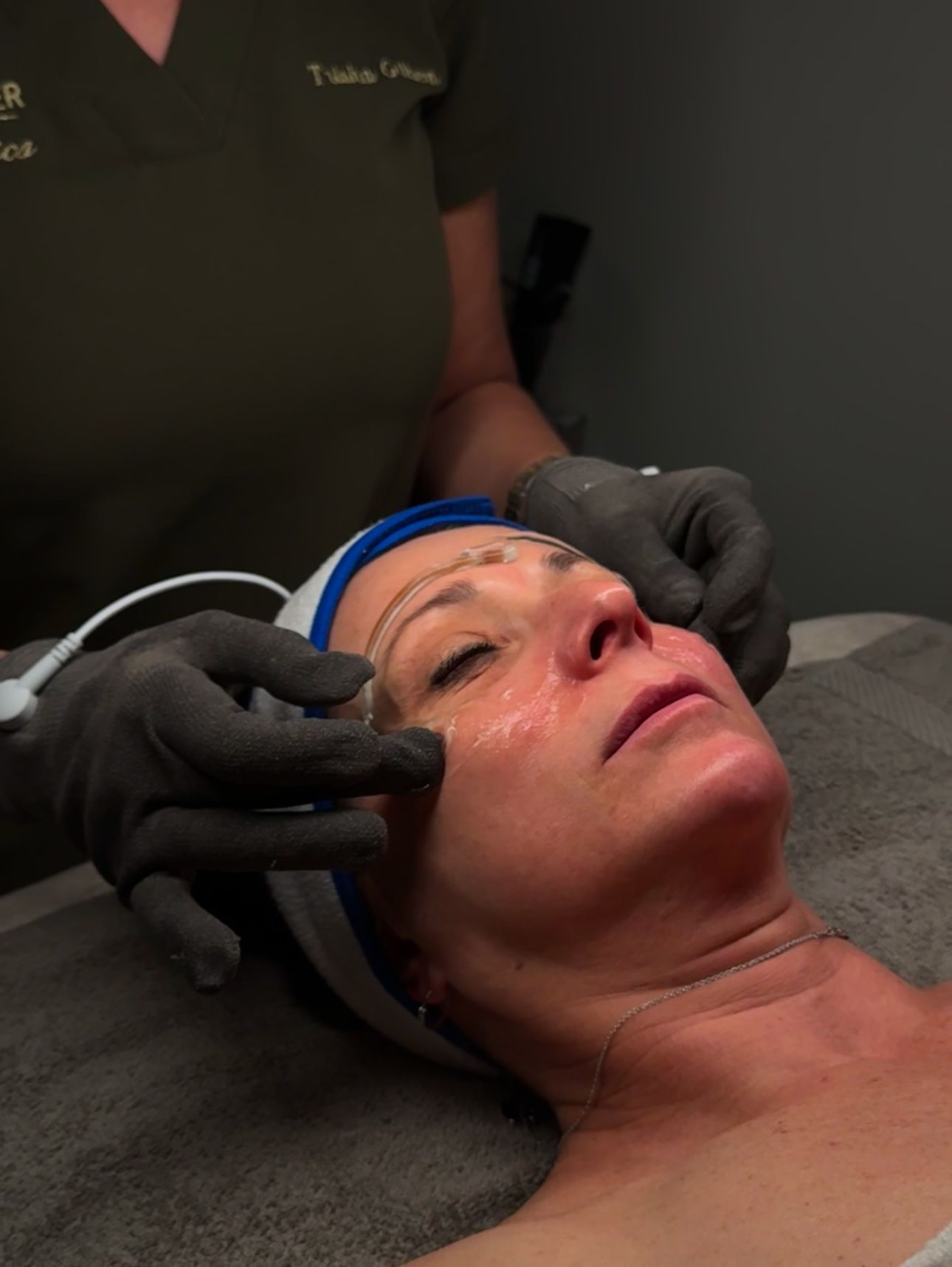 A woman is getting a facial treatment at a spa