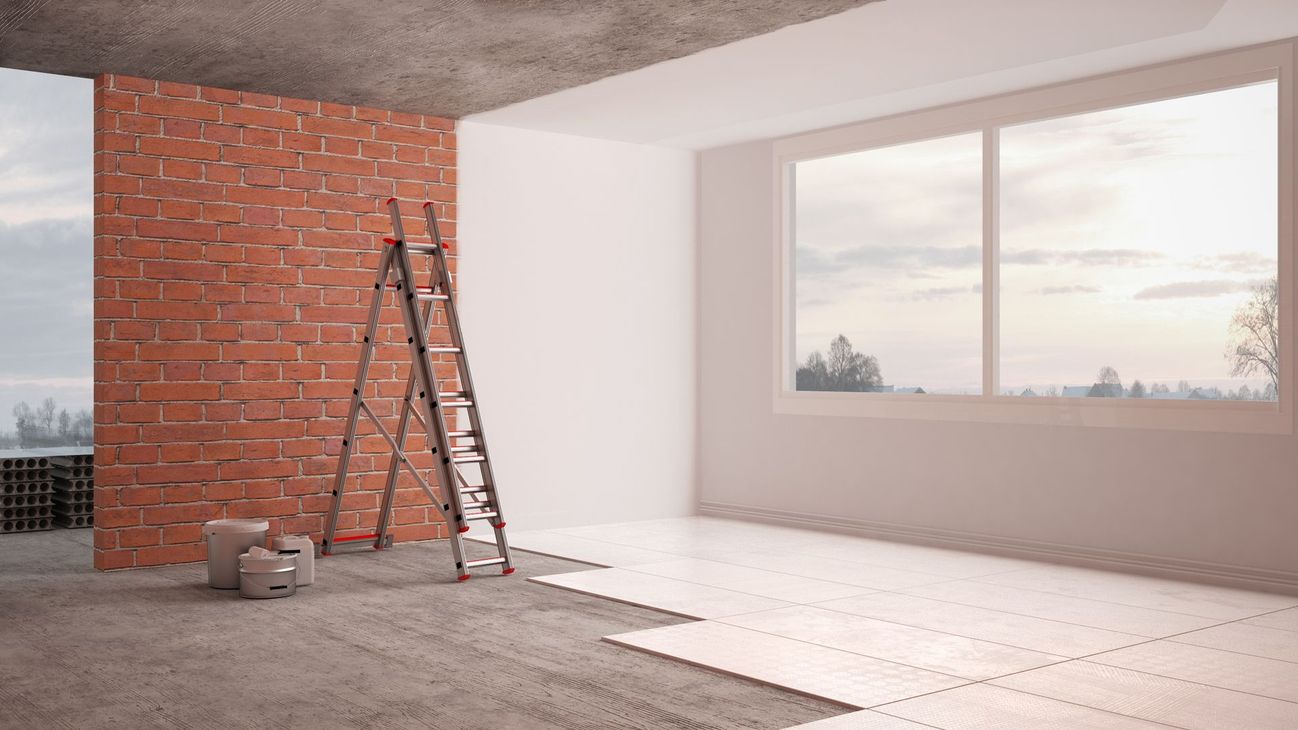 Partially renovated room with brick wall, ladder, and large window overlooking a snowy scene