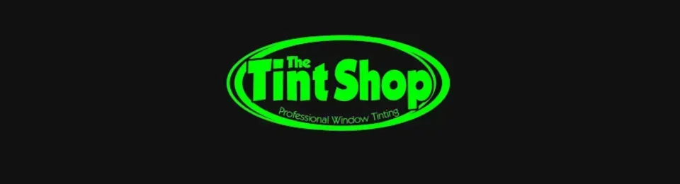 Neon green “The Tint Shop” logo on a black background