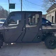 Dark gray off-road utility vehicle parked in a driveway, side view
