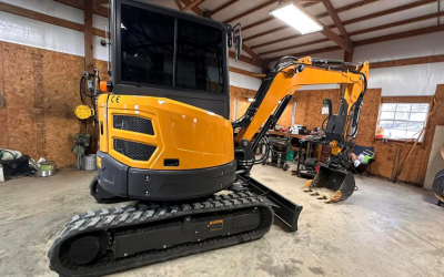 Yellow excavators parked inside a warehouse, one close in front and another in the background.