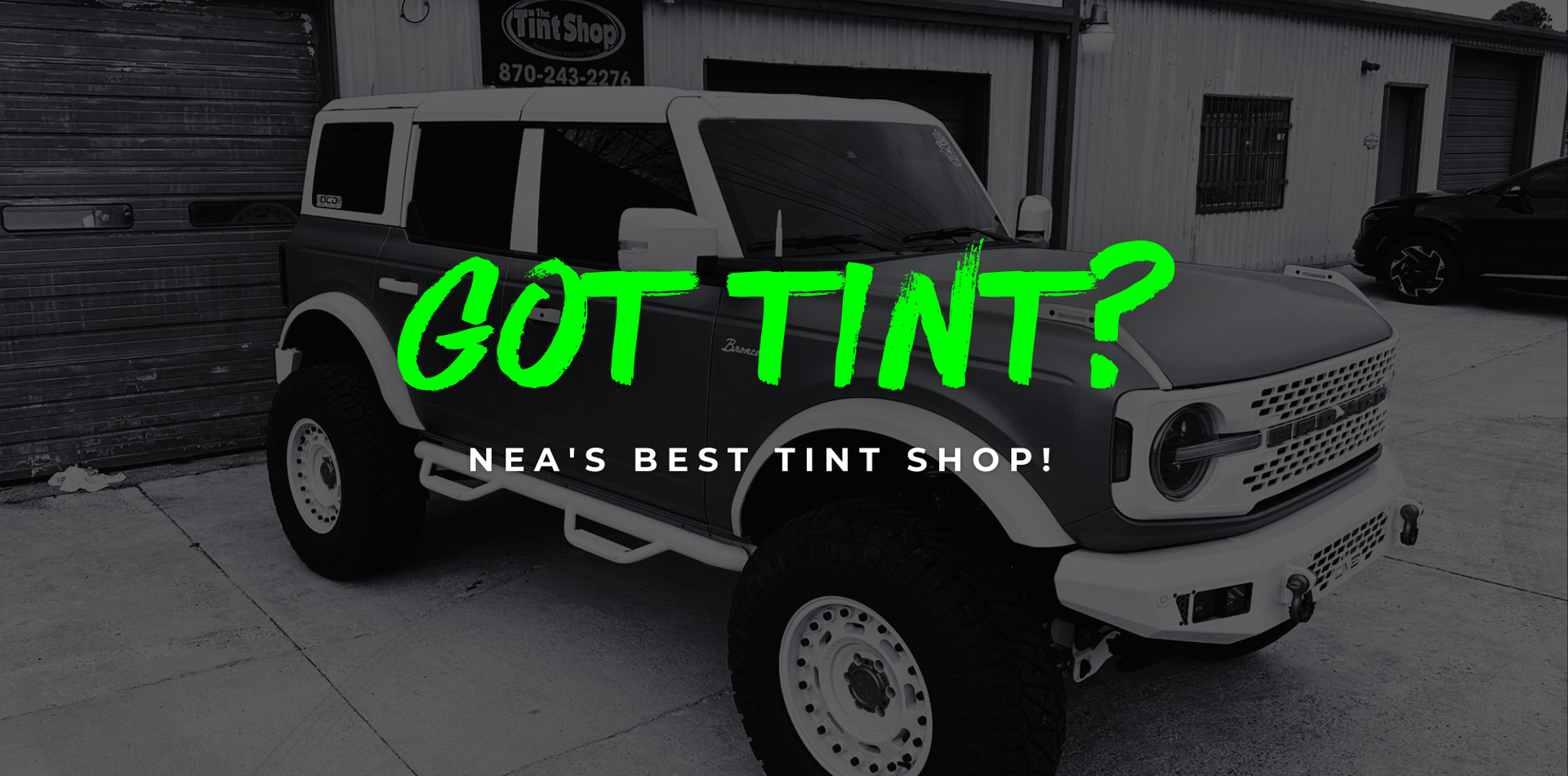 Dark storefront with green text reading “COMMERCIAL & RESIDENTIAL” and a parked car inside