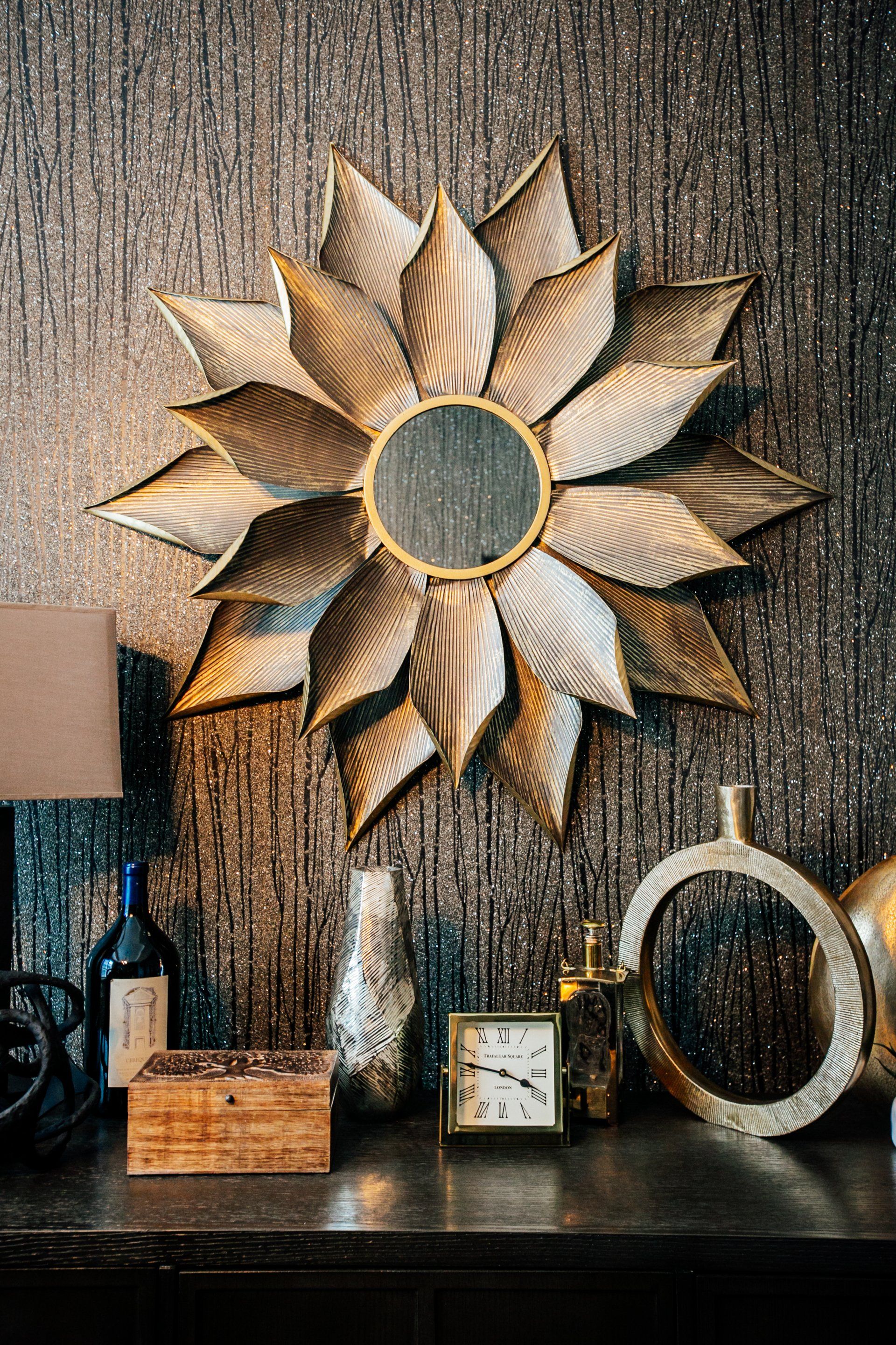 Flower petal mirror on wall with brown and black wood patterned wallpaper