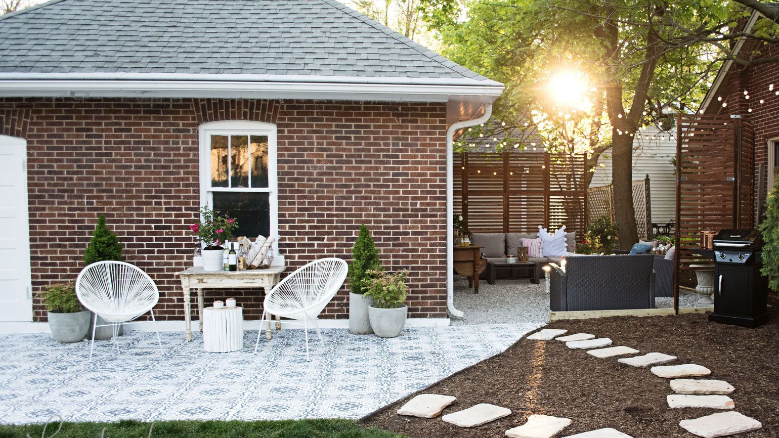 Brick home with two patio conversation areas brown wicker couches and white metal chairs