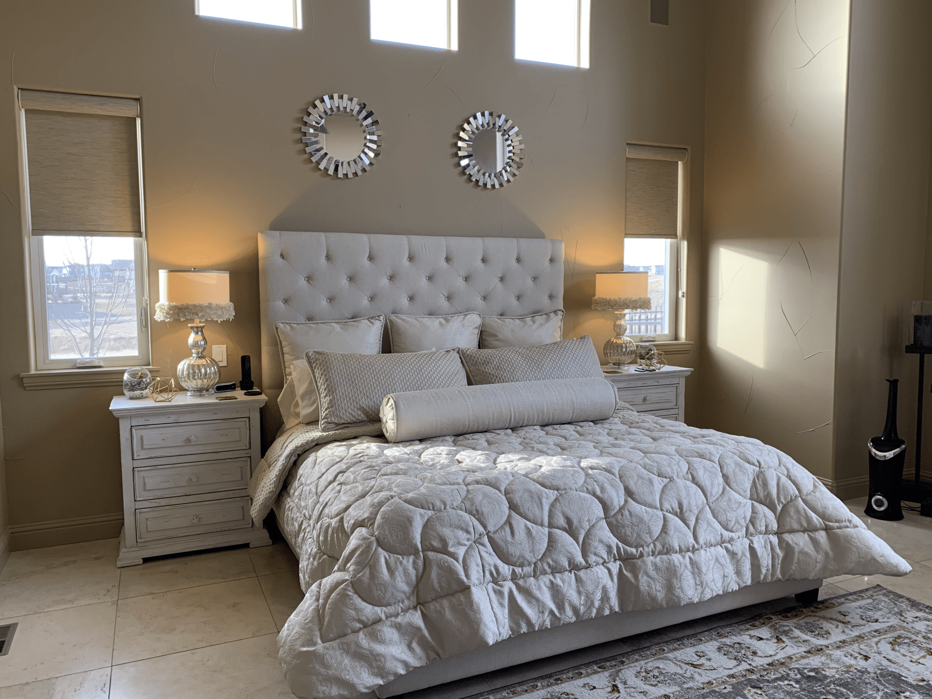 Taupe, white, and silver bedroom with tile floor and area rug