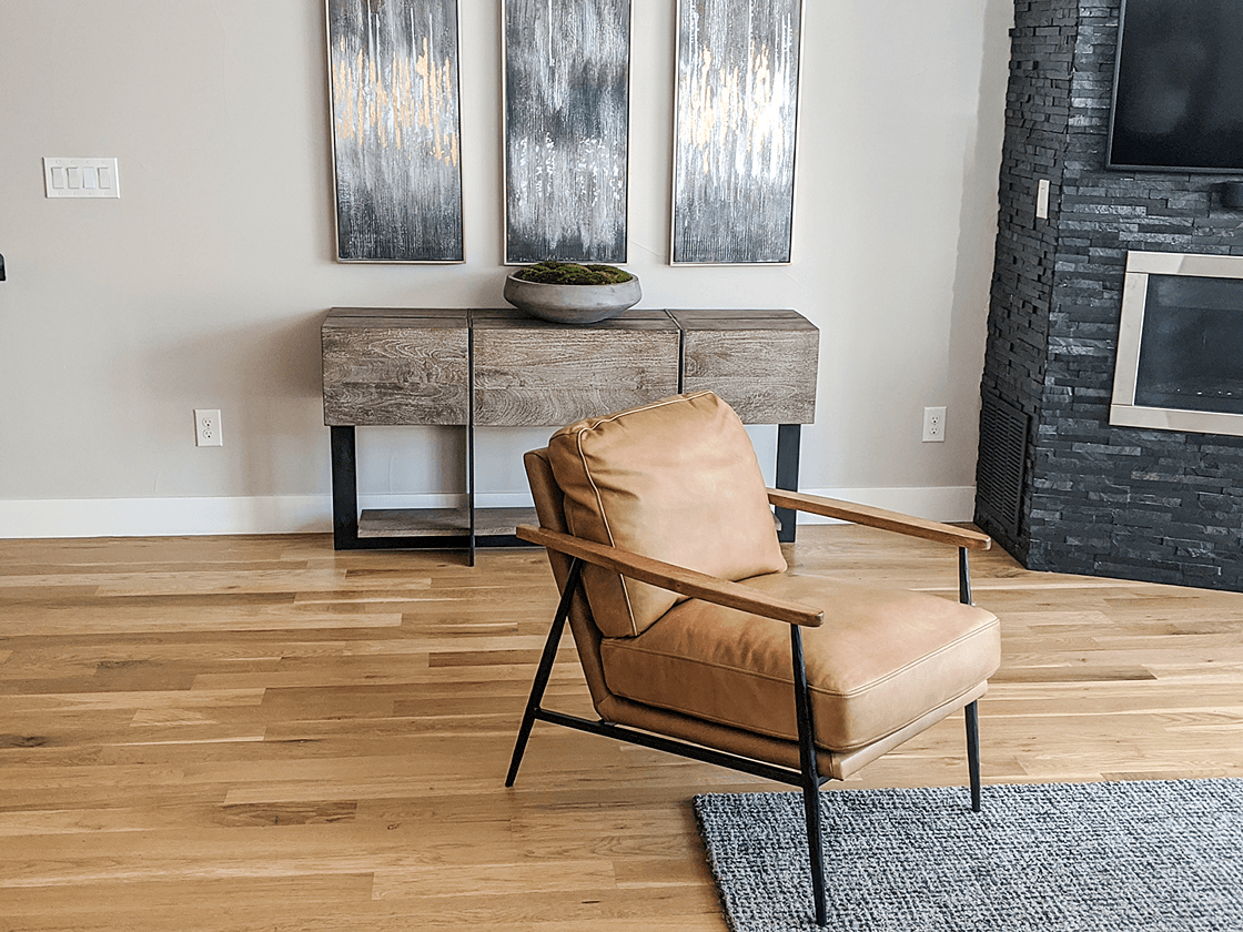 Tan leather chair partially on wood floor and area rug in living room