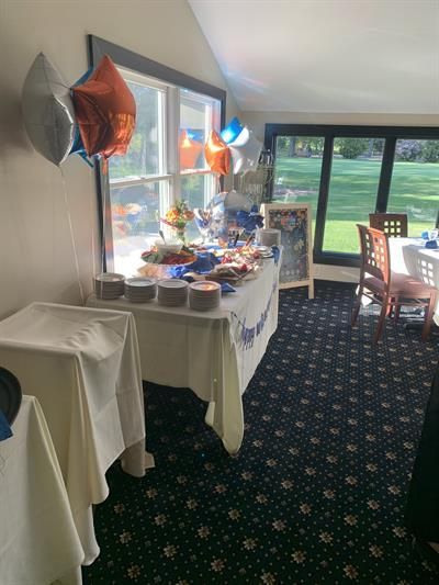 A room with tables and chairs and balloons on the wall.