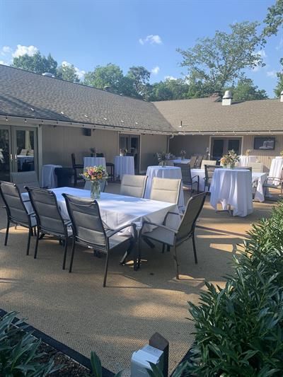A patio with tables and chairs set up for a party.