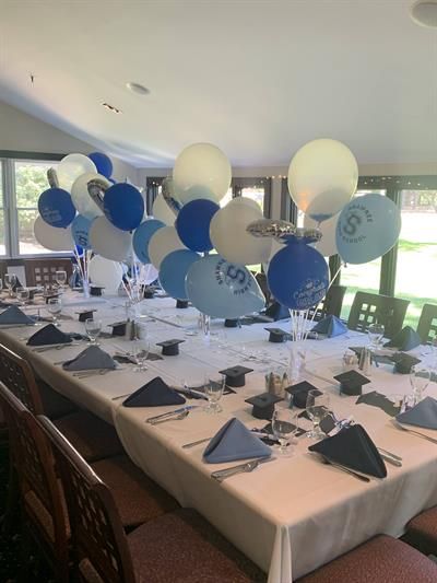 A long table with blue and white balloons on it