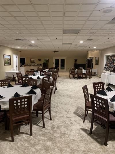 A large room with tables and chairs set up for a party.