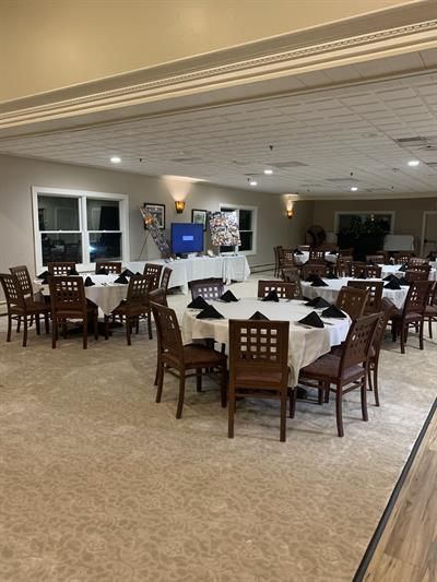 A large room with tables and chairs set up for a party.