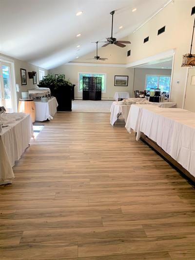 A large room filled with tables and a ceiling fan.