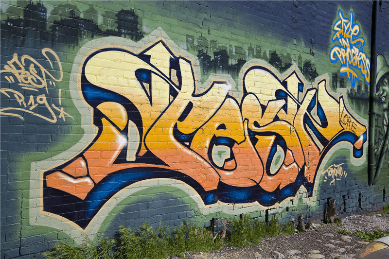 Remove graffiti on a brick wall. 