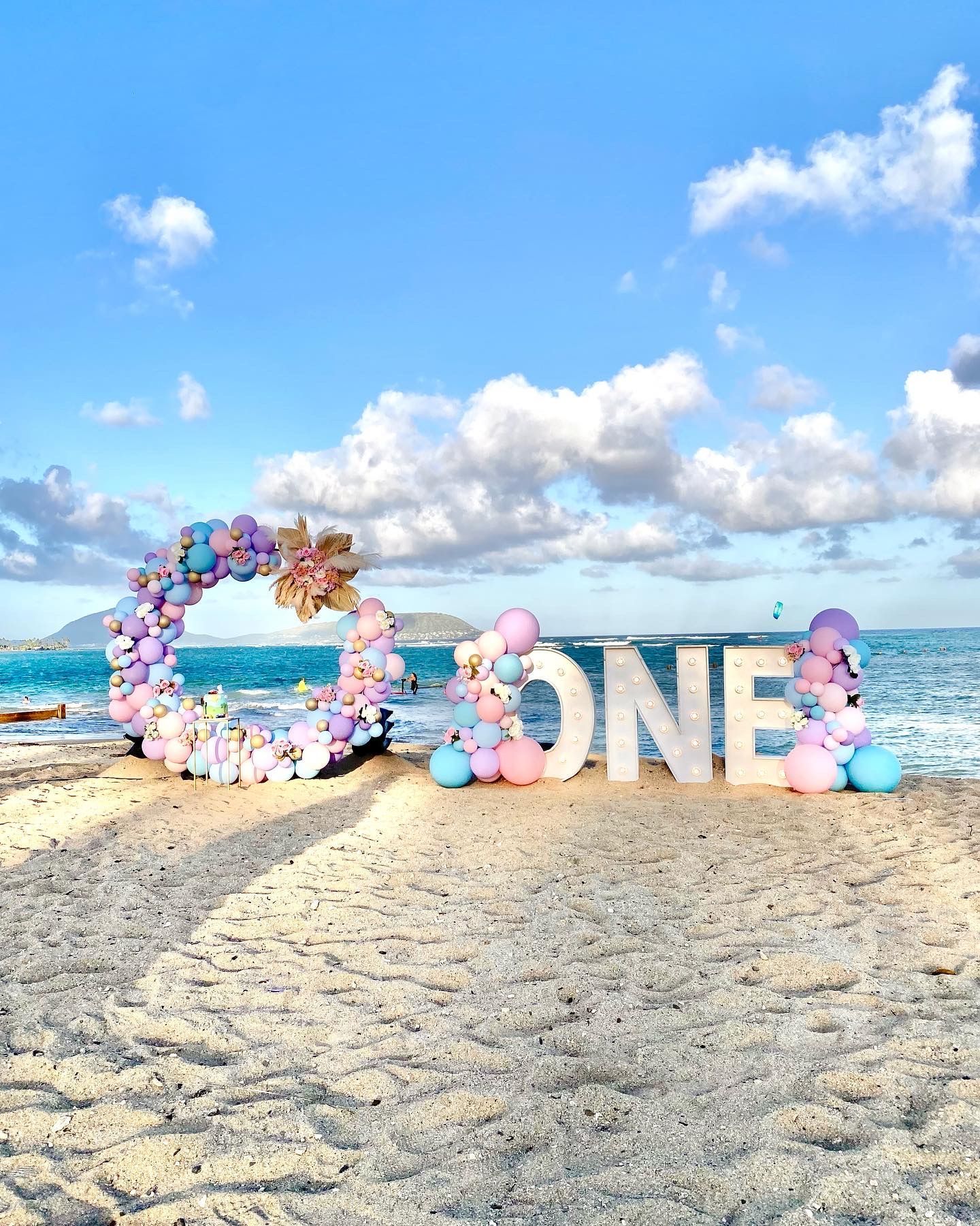 The word one is made of balloons on the beach.