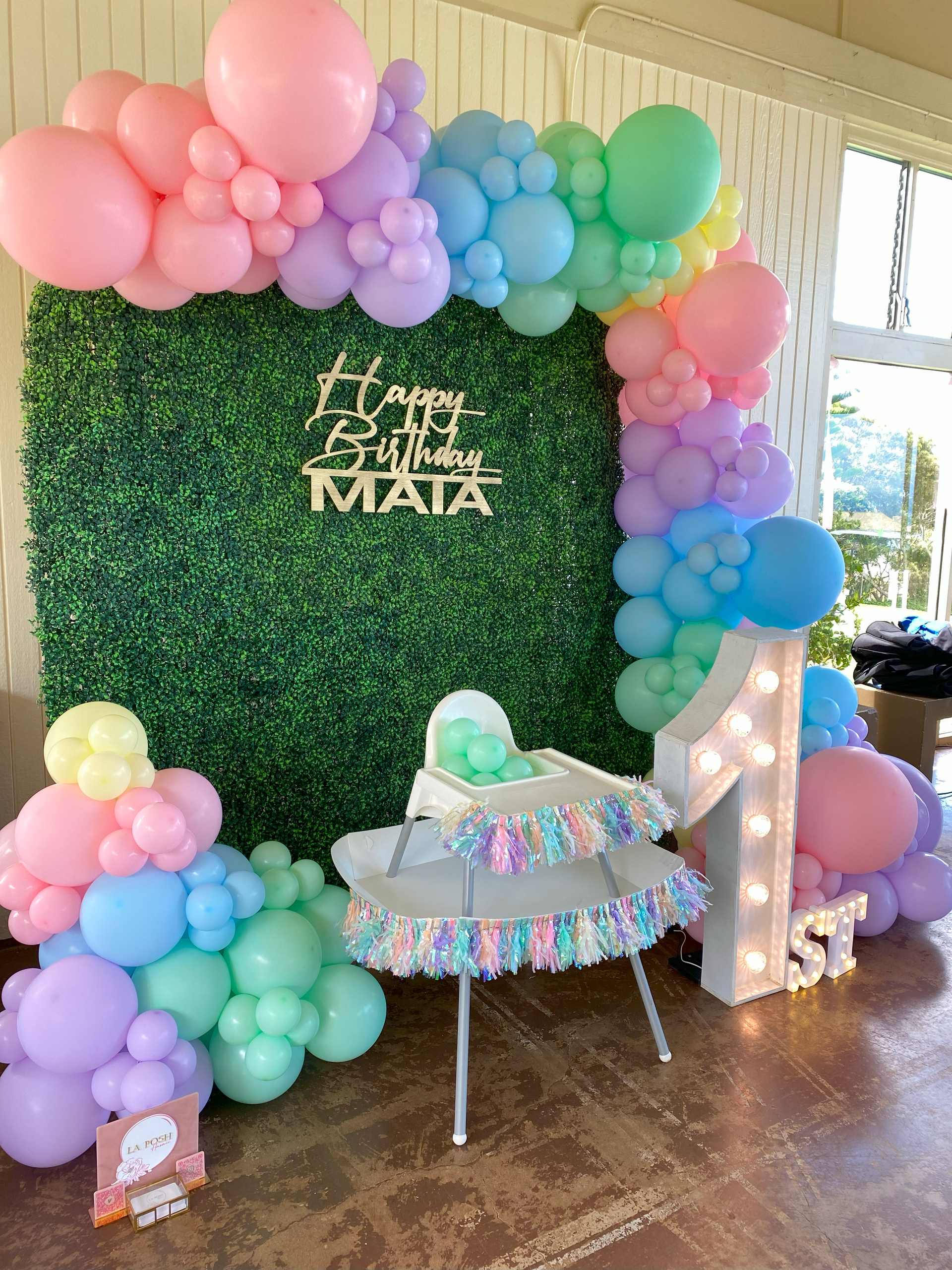 A room filled with balloons and a high chair.