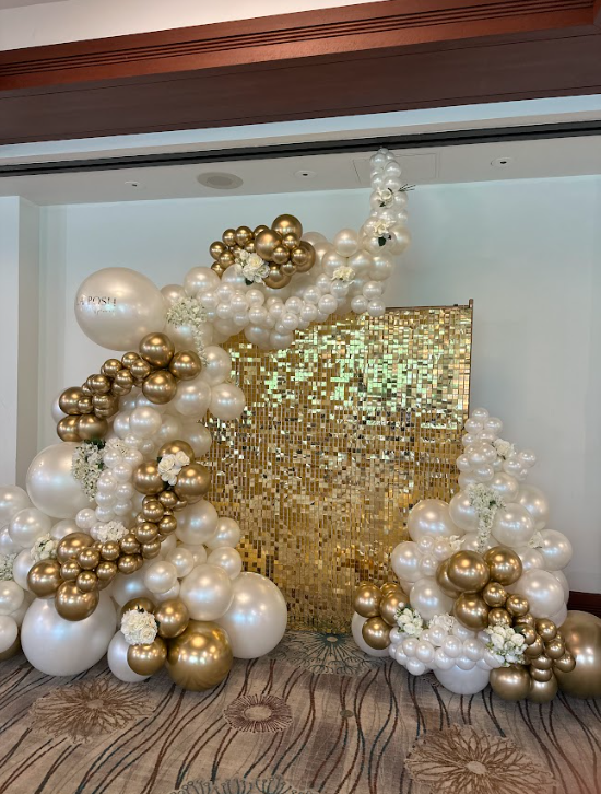 A room filled with lots of white and gold balloons.