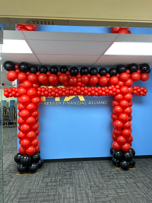 Red and black balloons are arranged in the shape of a t