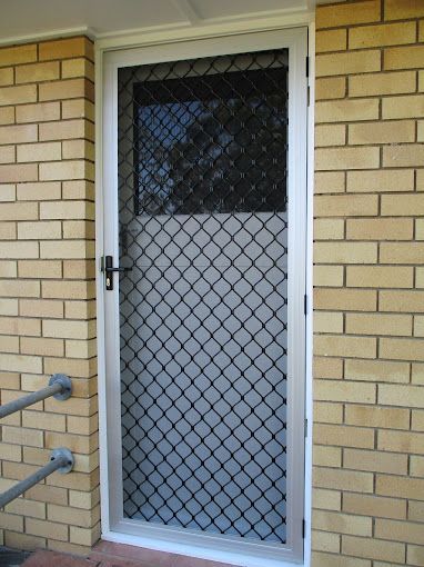 A bedroom with a bed , chair , and sliding panels on the wall.