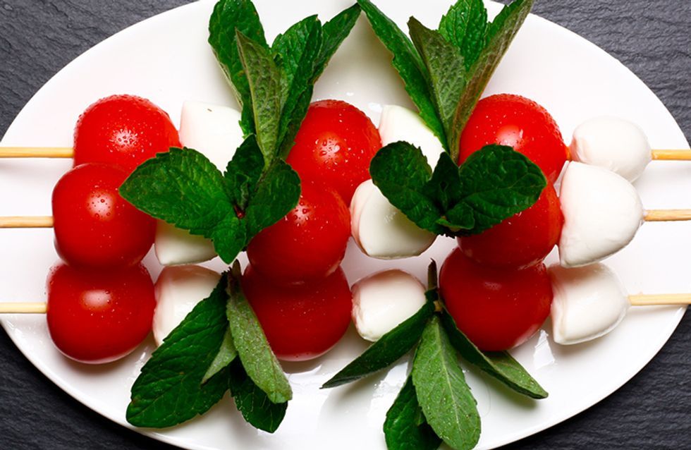 Tomate e mussarela no espeto com folhas de hortelã em um prato branco