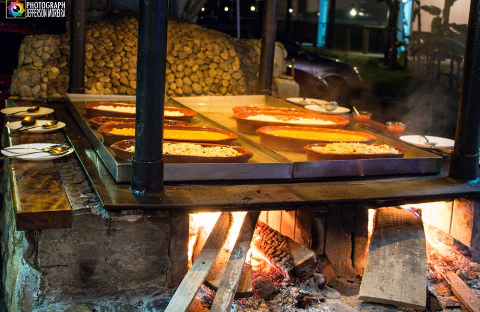 Uma grande bandeja de comida está em cima de uma fogueira.