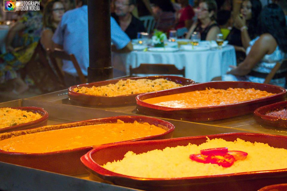 Um monte de tigelas de comida estão sobre a mesa de um restaurante.