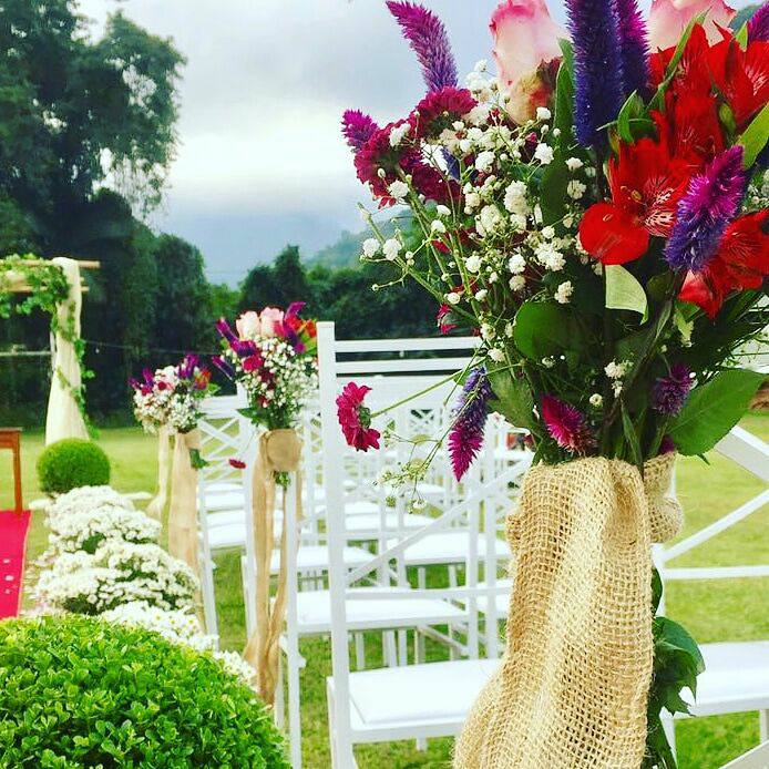 Uma fileira de cadeiras brancas com flores