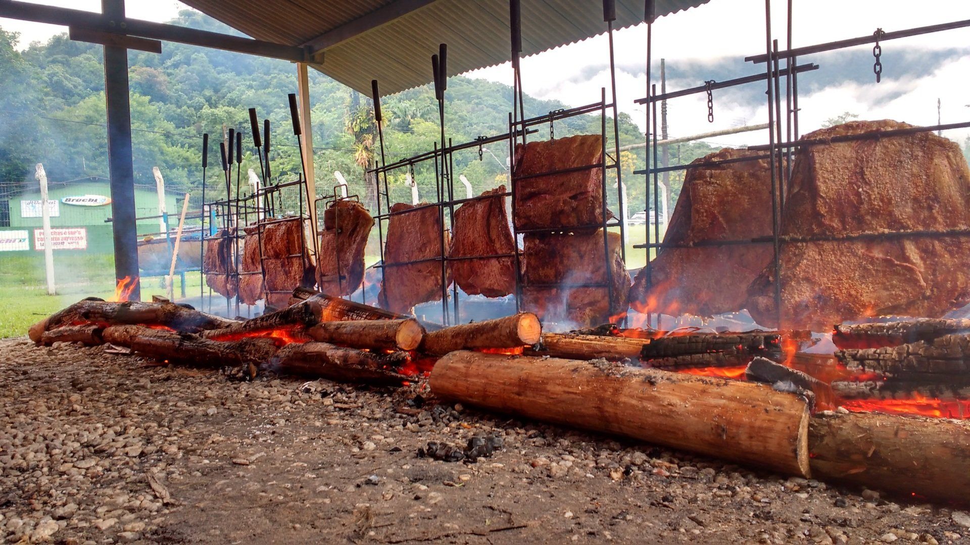 Uma grande quantidade de carne está sendo cozida no fogo