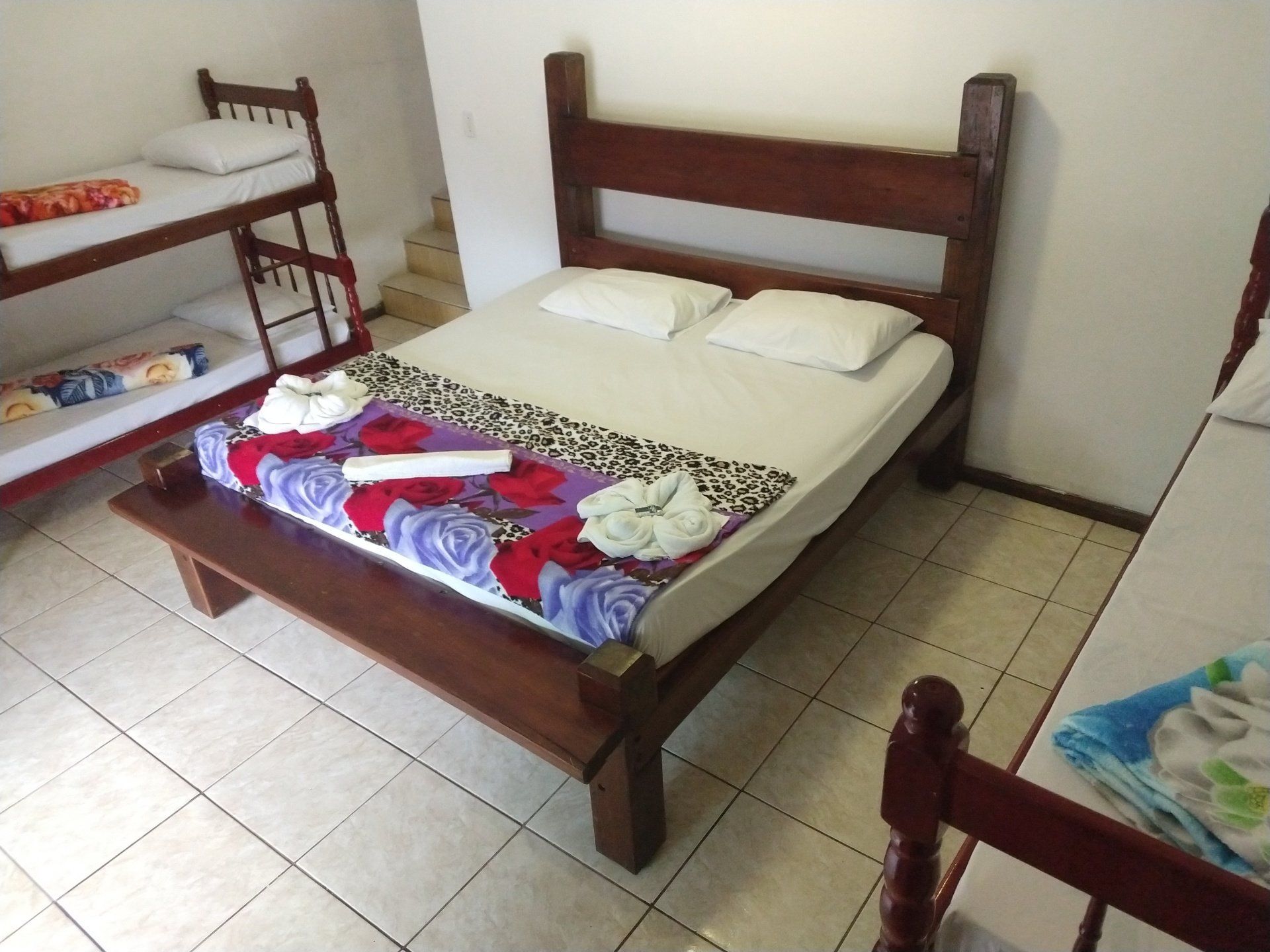 Um quarto com uma cama e dois beliches