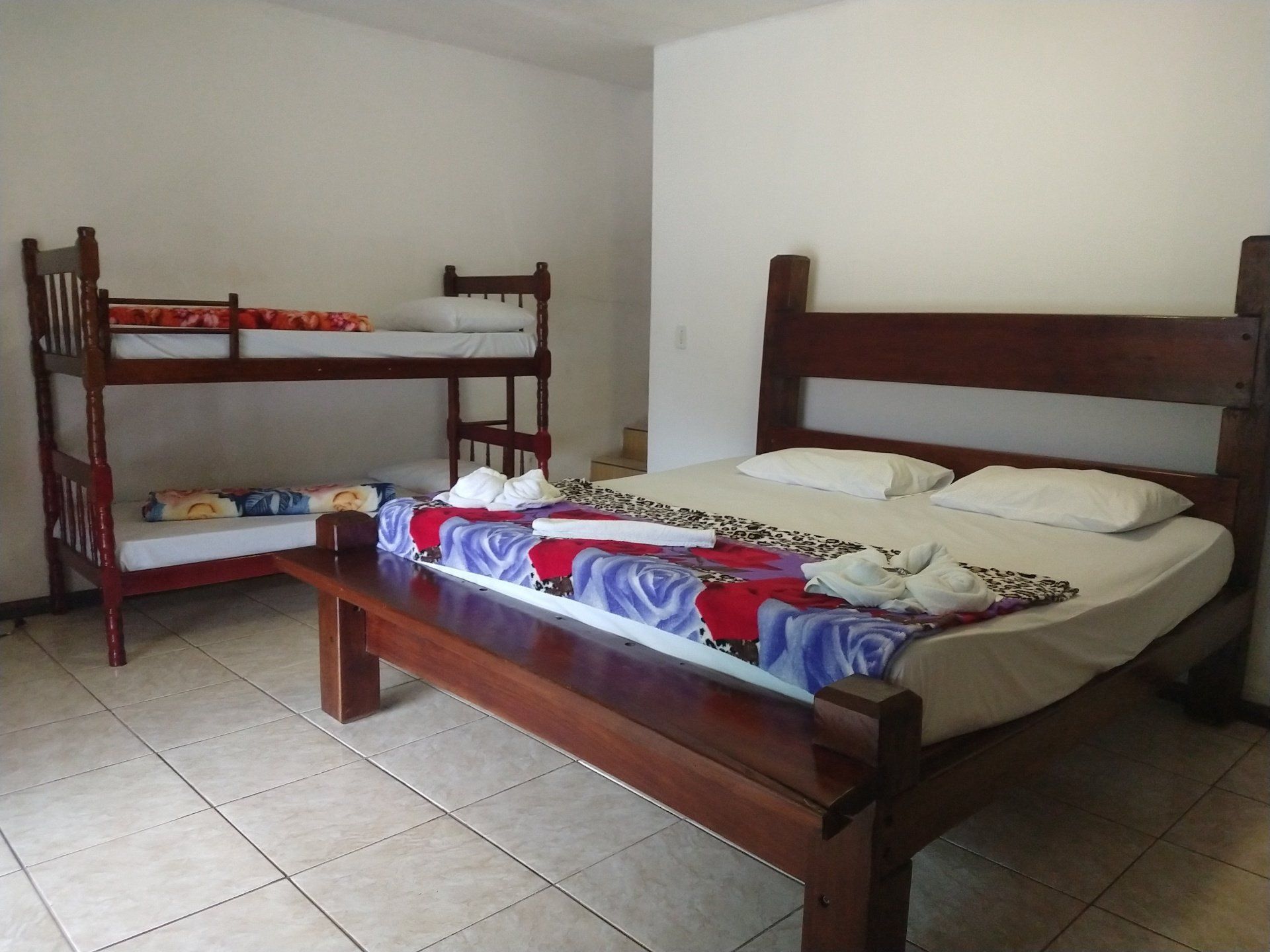 Um quarto com duas camas e dois beliches