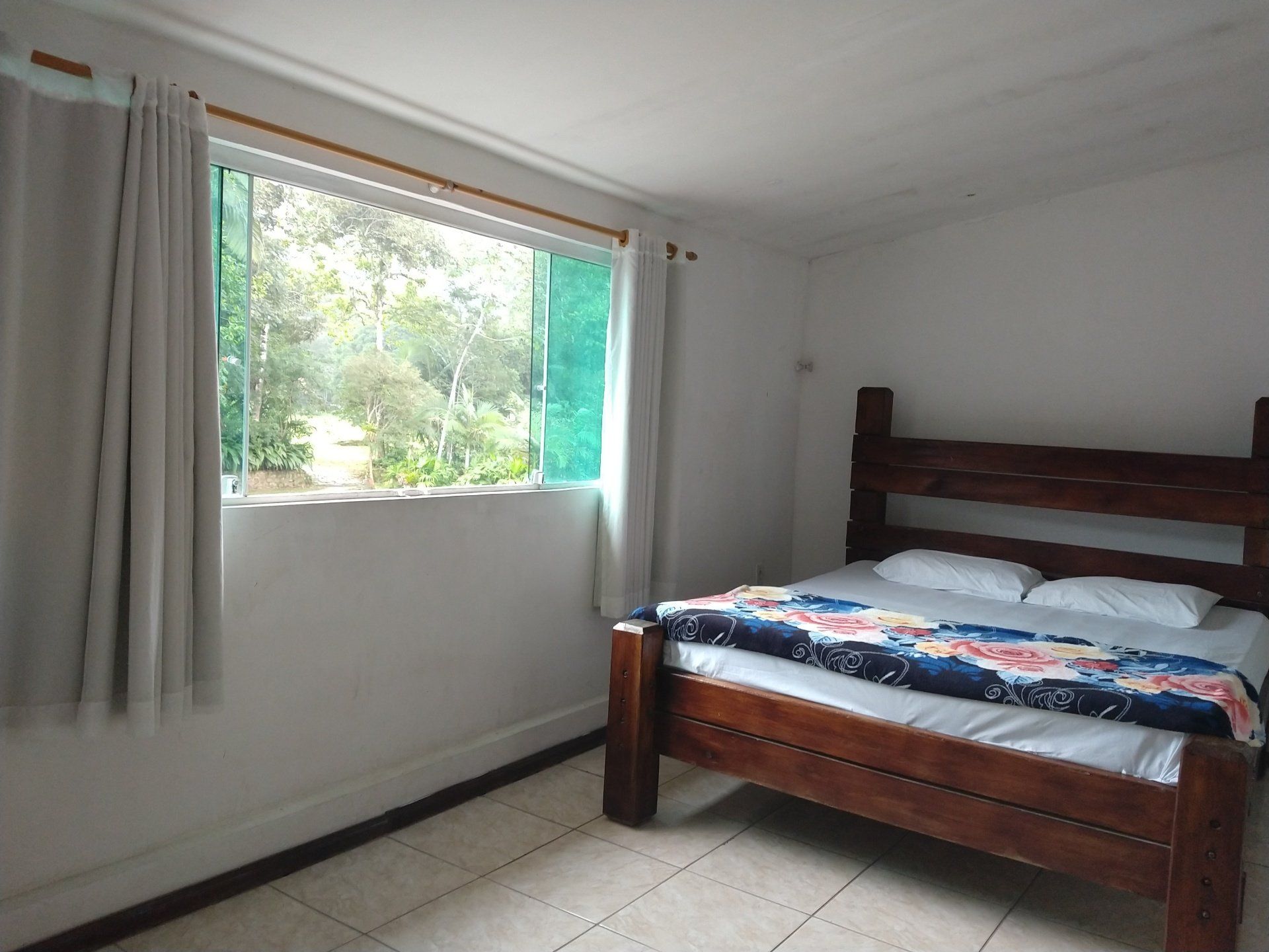 Um quarto com uma cama grande e uma janela