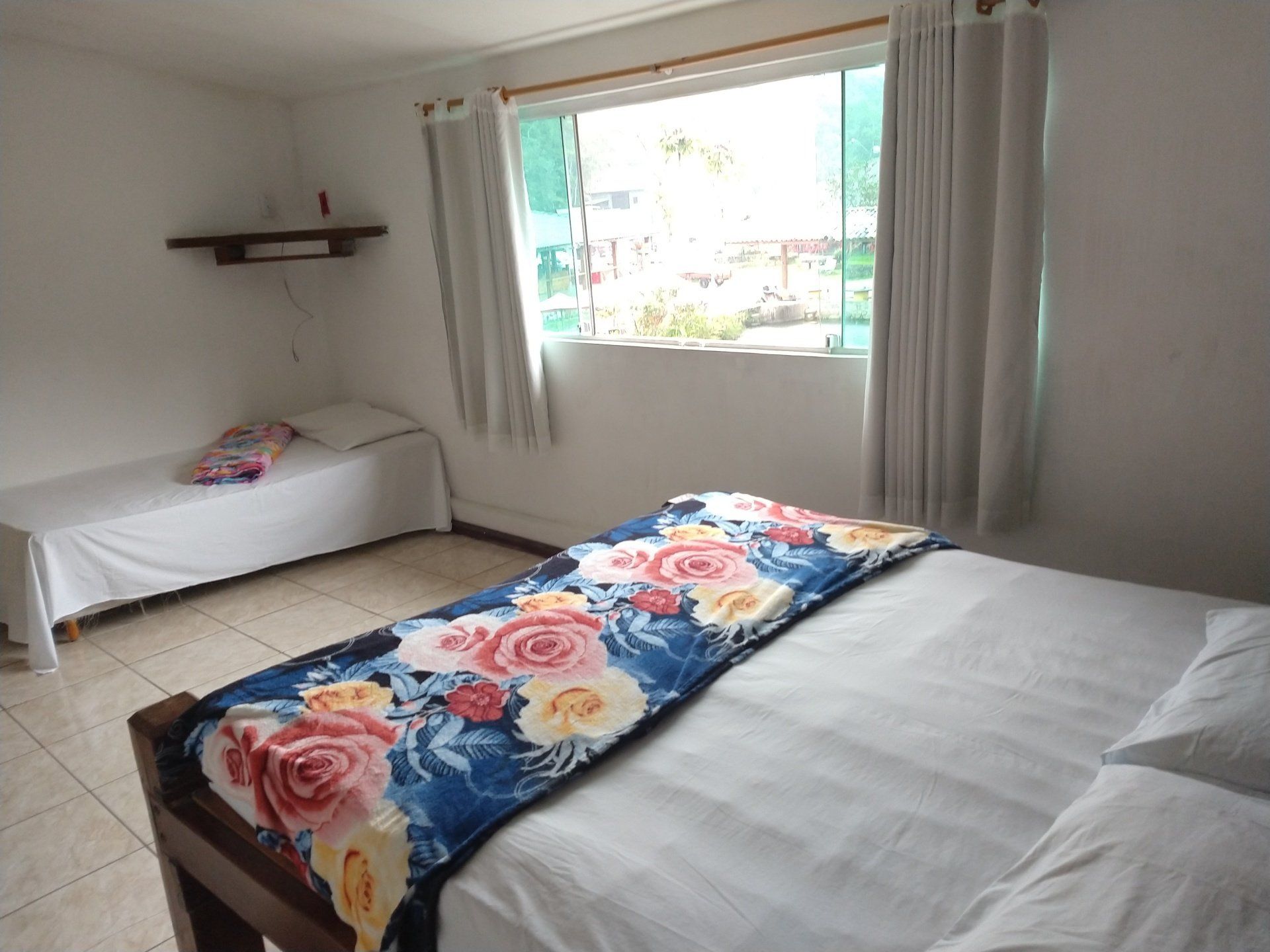 Um quarto com uma cama, duas camas e uma janela.