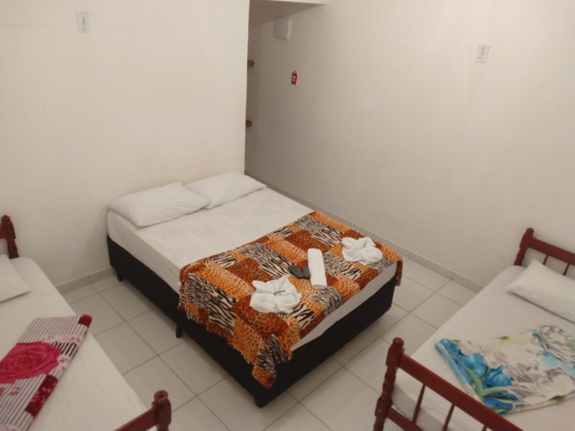 Um quarto de hotel com uma cama e duas camas de solteiro