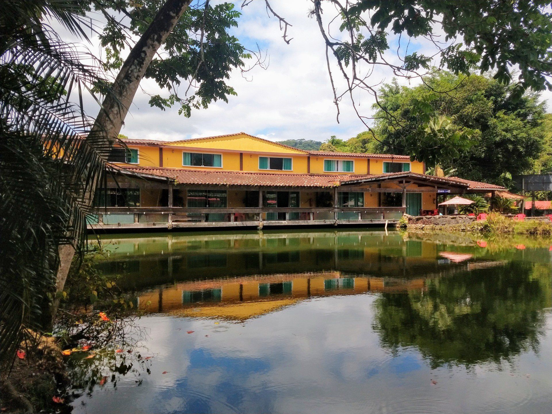 Um grande edifício amarelo fica próximo a um corpo de água