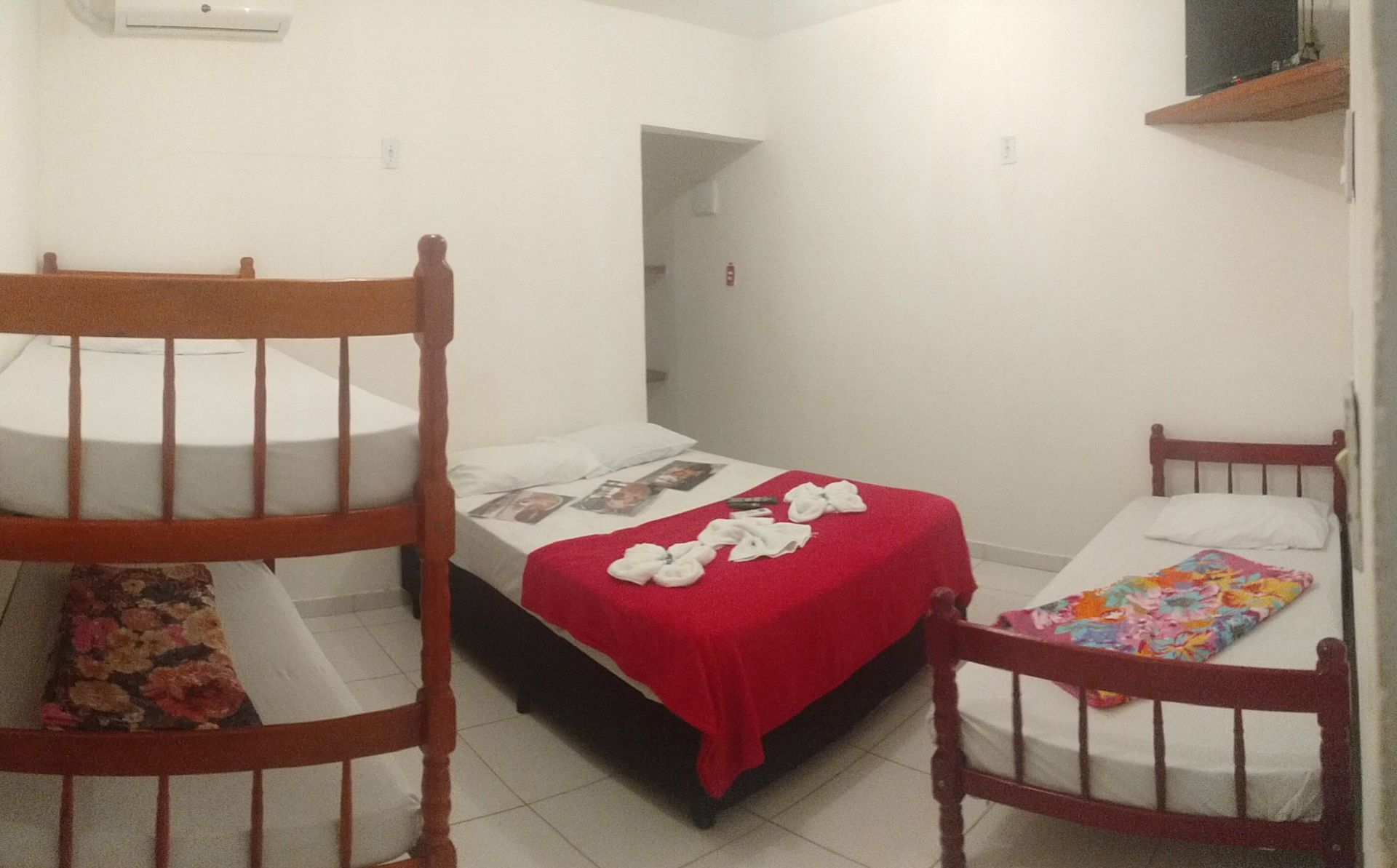 Um quarto com uma cama e dois beliches