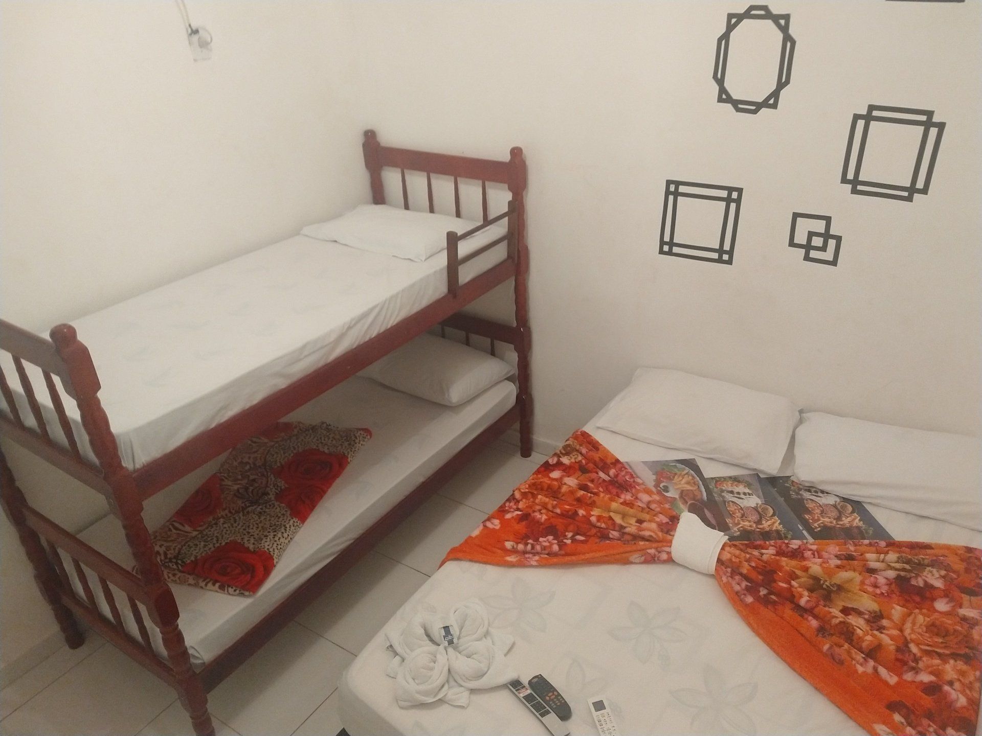 Um quarto com dois beliches e uma cama de solteiro