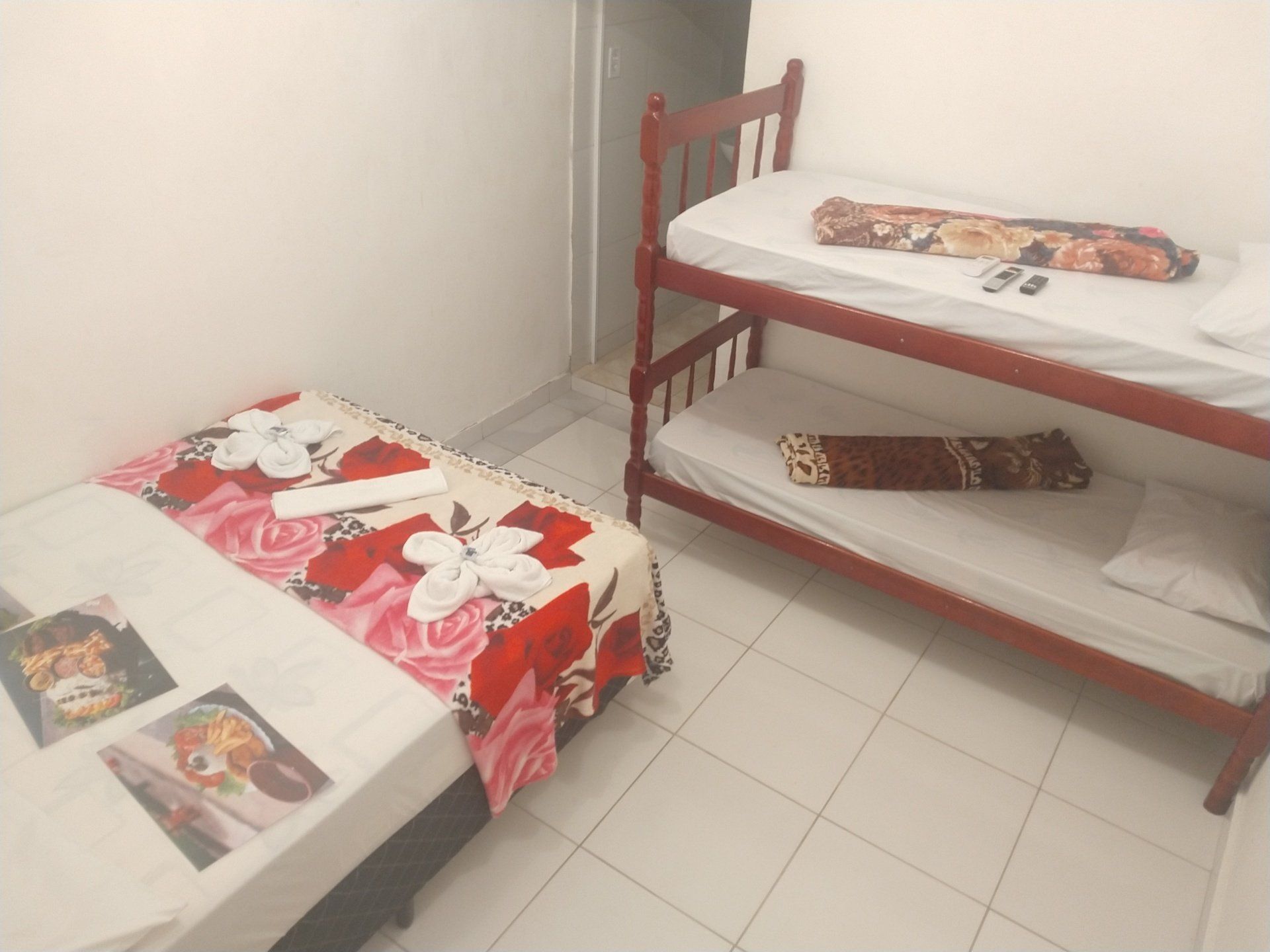 Um quarto com dois beliches e uma cama de solteiro