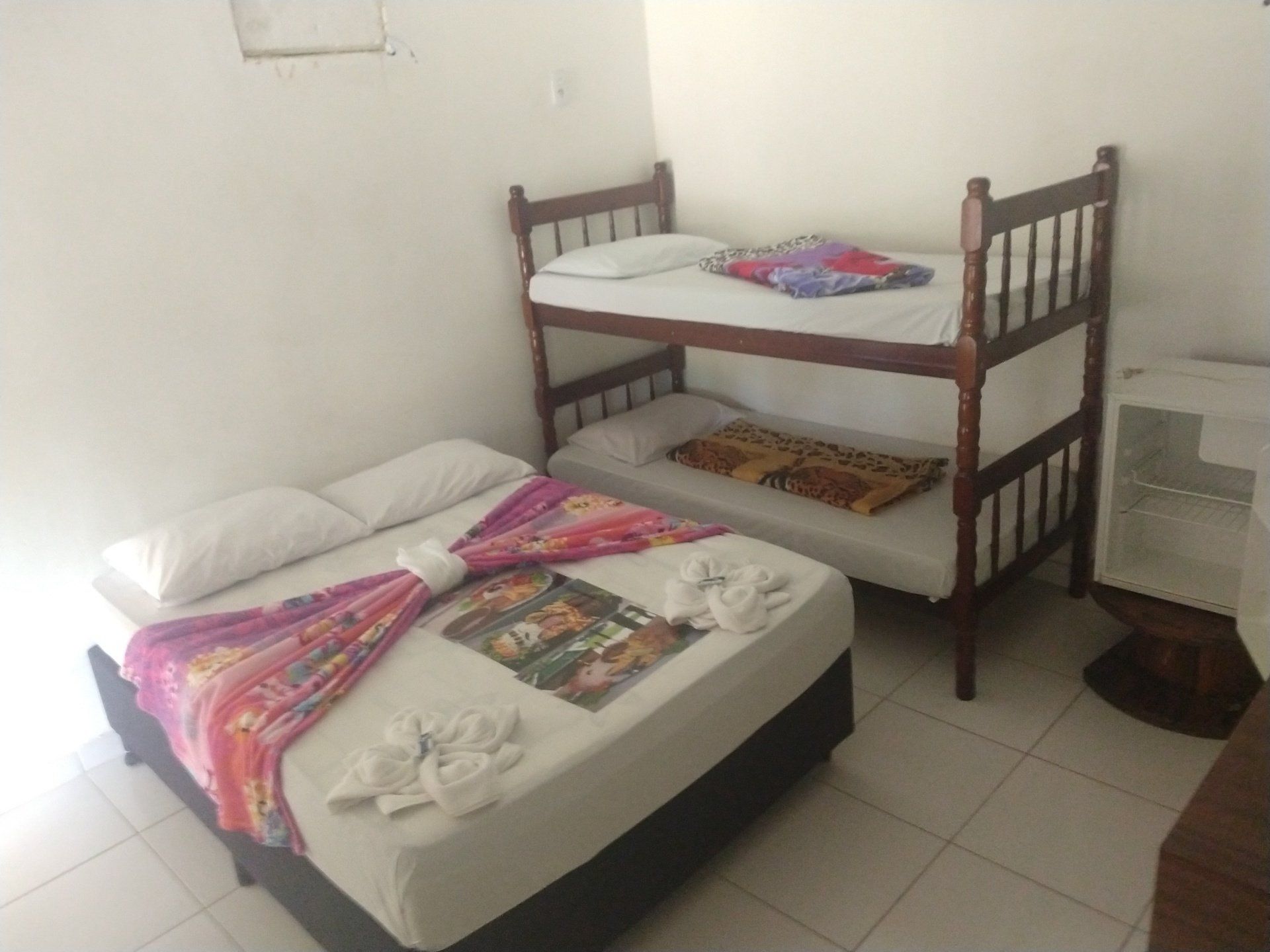 Um quarto com duas camas e um beliche