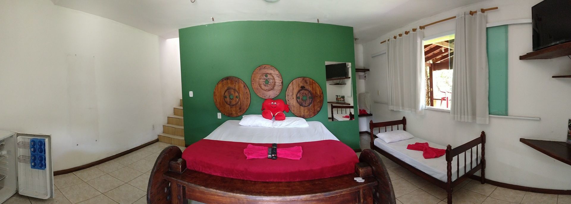 Um quarto com uma cama, duas camas e uma parede verde.