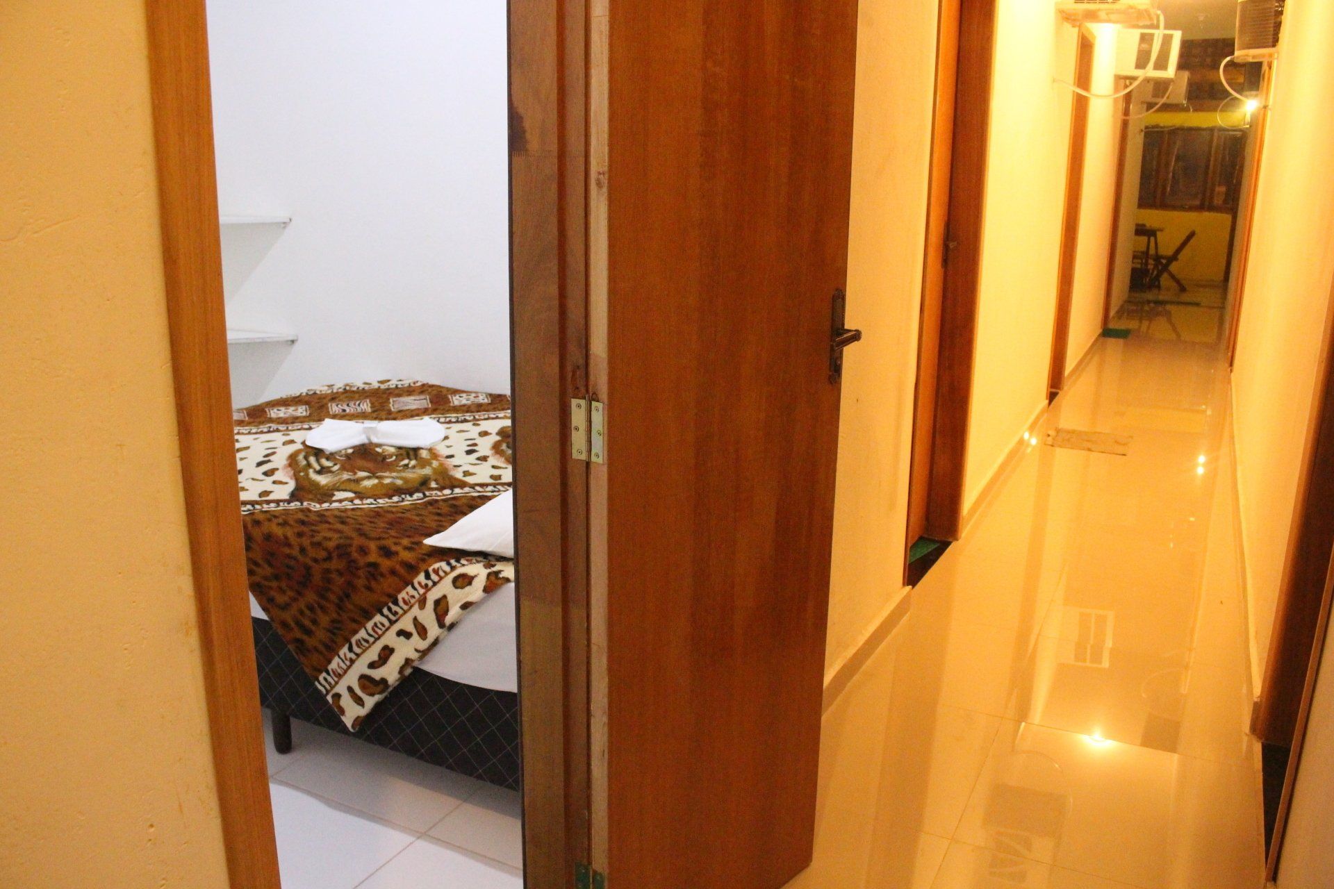 Um corredor que leva a um quarto com uma colcha com estampa de leopardo
