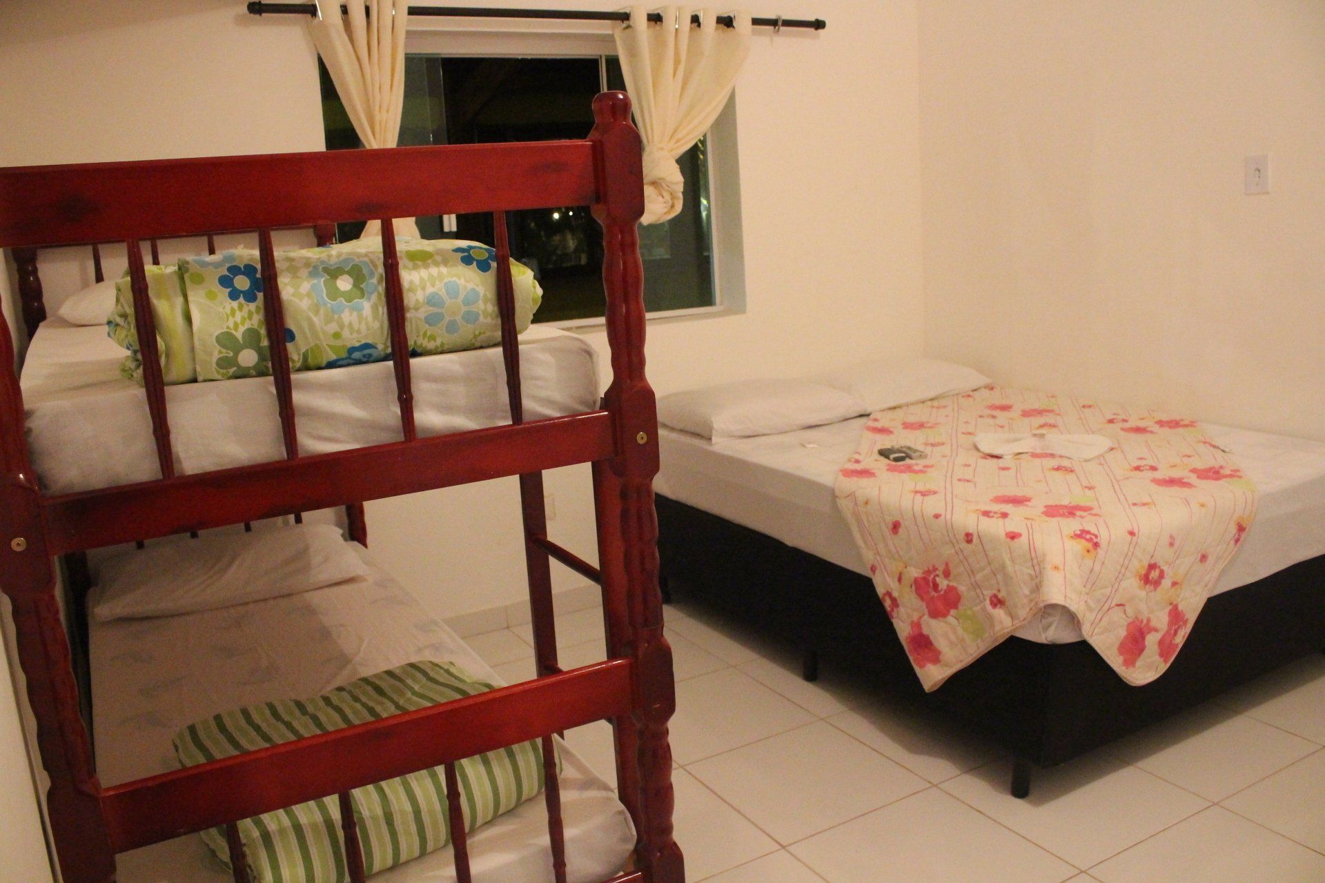 Um quarto com duas camas e um beliche