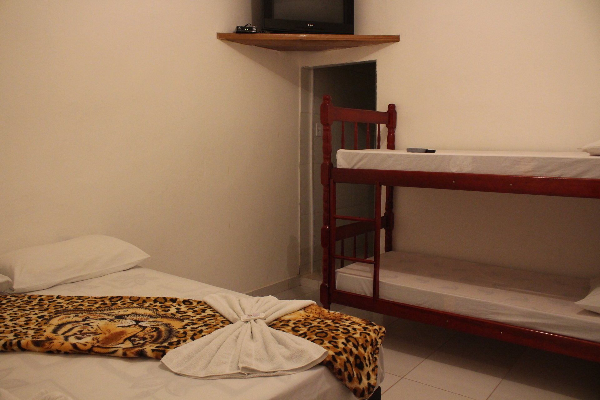 Um quarto com duas camas e um beliche.