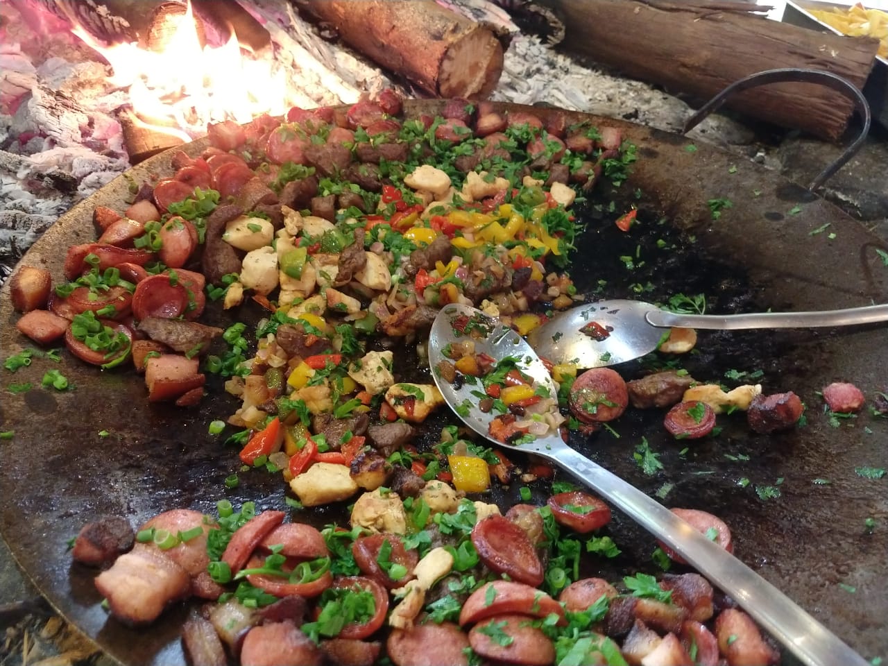 Um prato de comida com duas colheres e um fogo ao fundo
