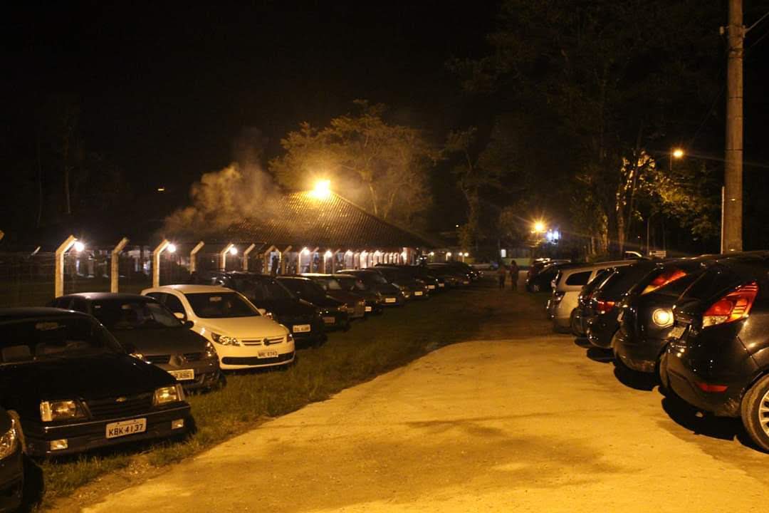 Muitos carros ficam estacionados em um estacionamento à noite.