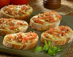 Um close de um prato de comida com tomate e queijo em uma mesa.