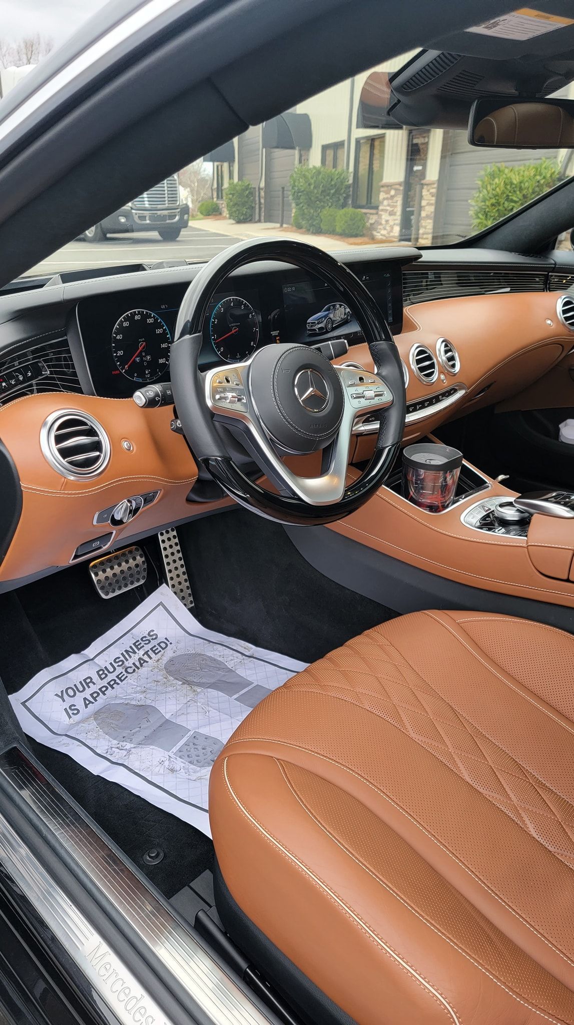 White Corvette sports car with red racing stripes, indoors.