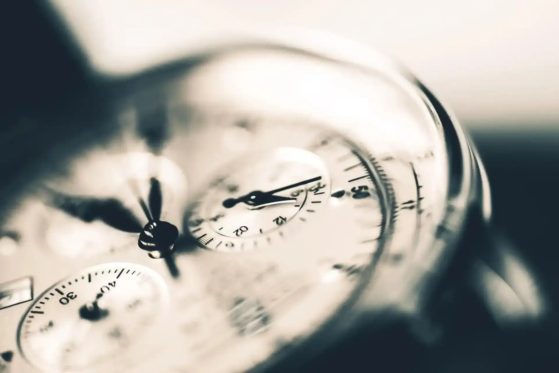 Primo piano di un orologio da polso analogico argentato con i quadranti sfocati sullo sfondo.