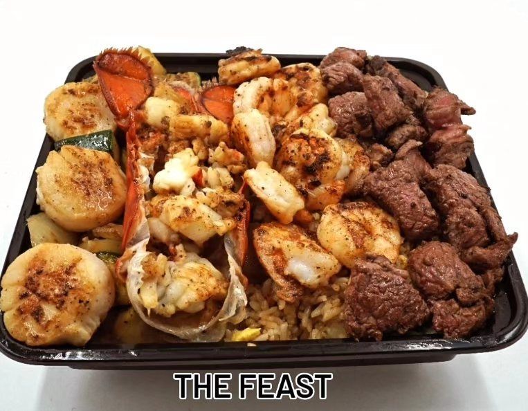 A tray of food with shrimp , steak , scallops and rice.